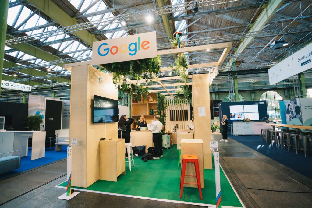 Google's exhibition stand with greenery at a tech expo.