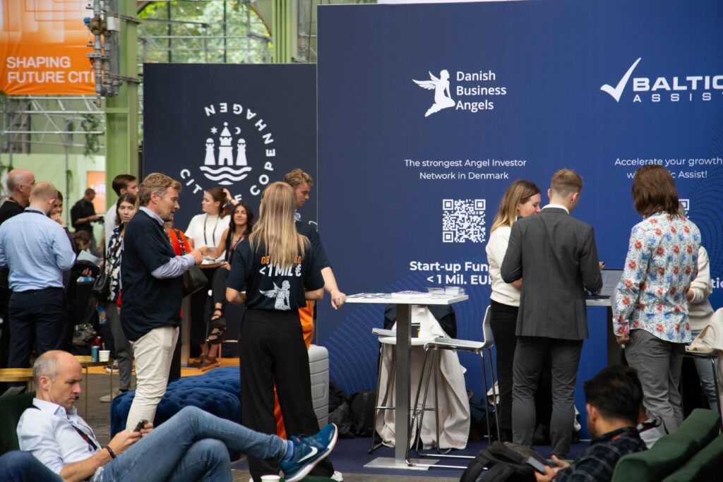 Startup representatives and investors converse near Danish Business Angels and Baltic Assist booths at TechBBQ.