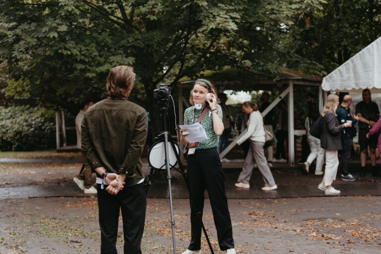 TechBBQ interviewer preparing to film an attendee outdoors.